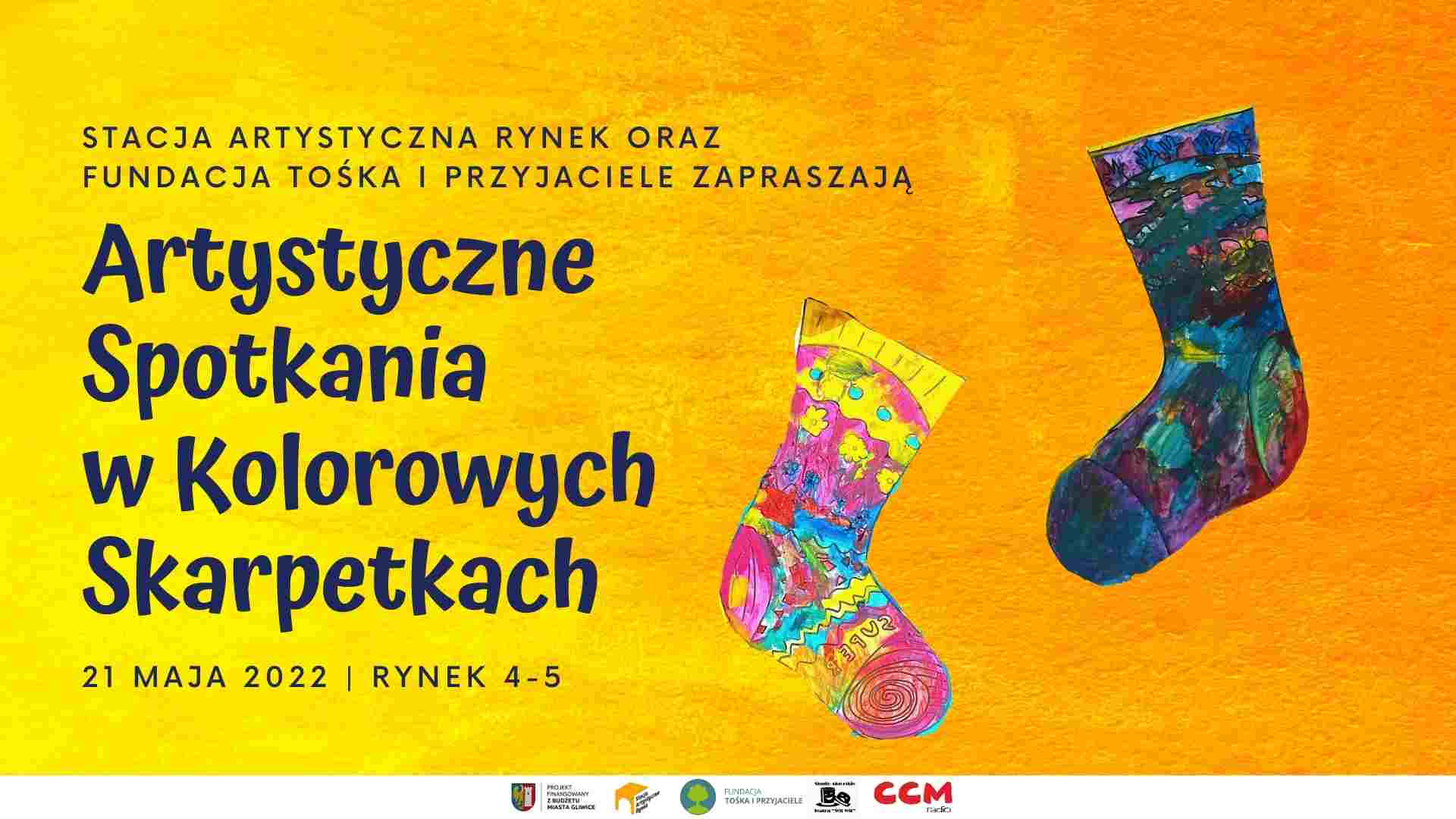 Rysunki kolorowych skarpet na żółto-pomarańczowym tle, obok napis "Artystyczne spotkania w kolorowych skarpetkach"