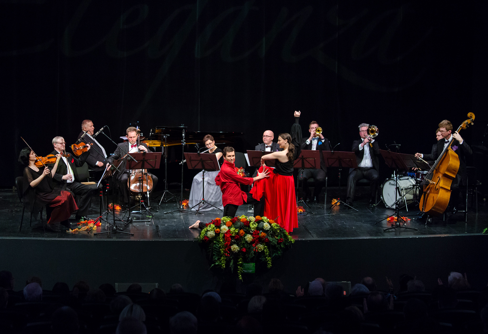 muzycy grają, tancerze w czerwieni tańczą