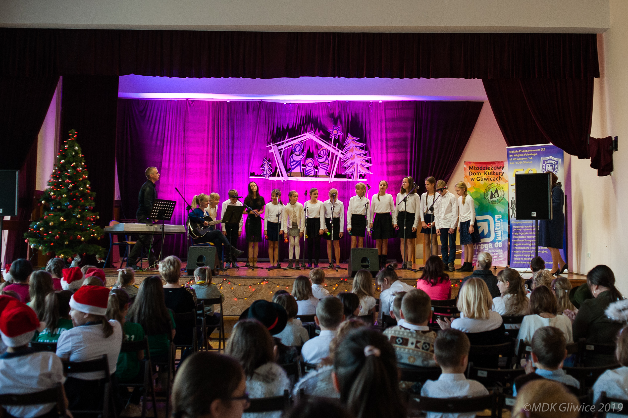 duża grupa dzieci w białych koszulach na scenie