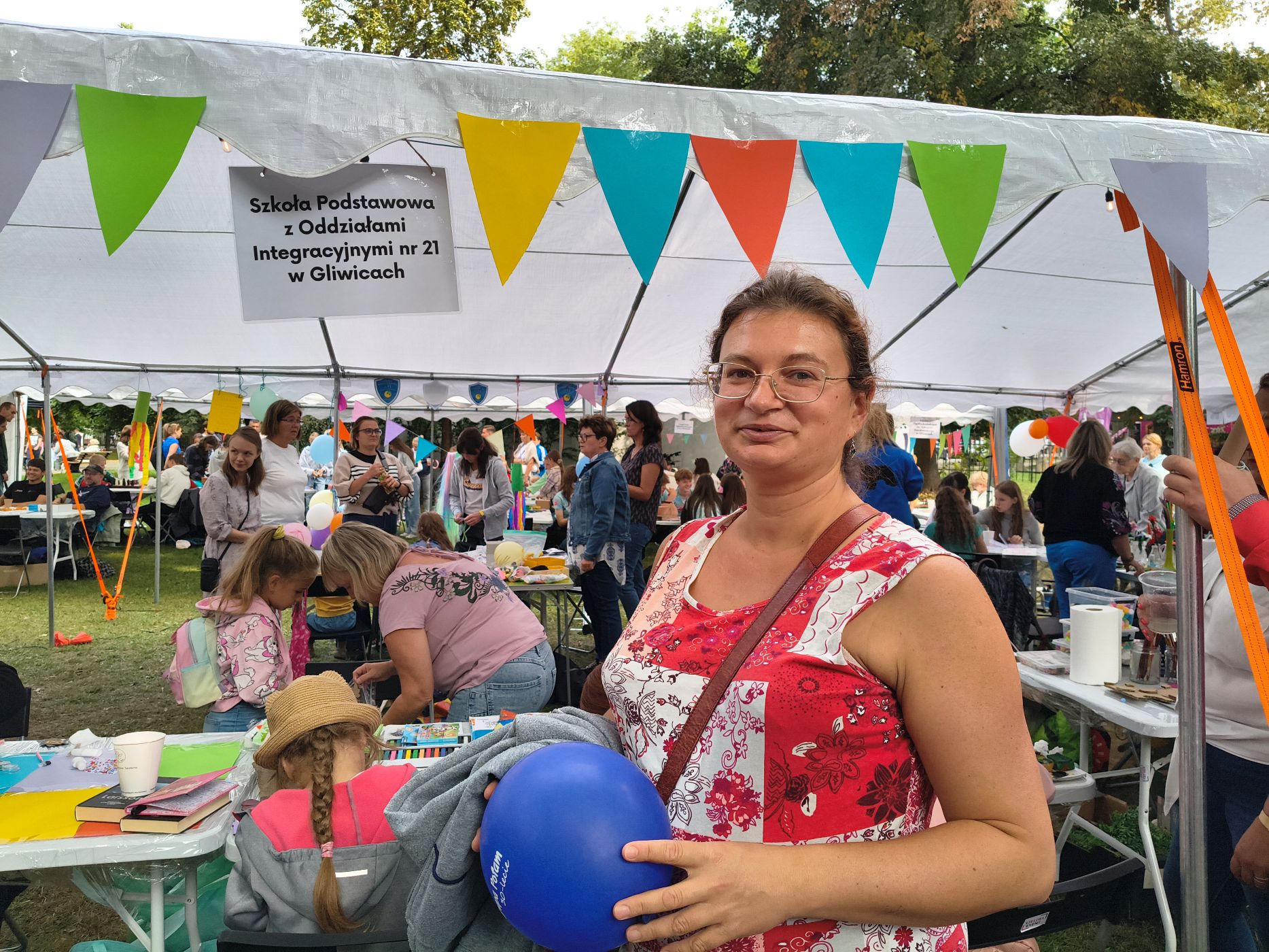 kobieta w czerwono-białej sukience z granatowym balonem