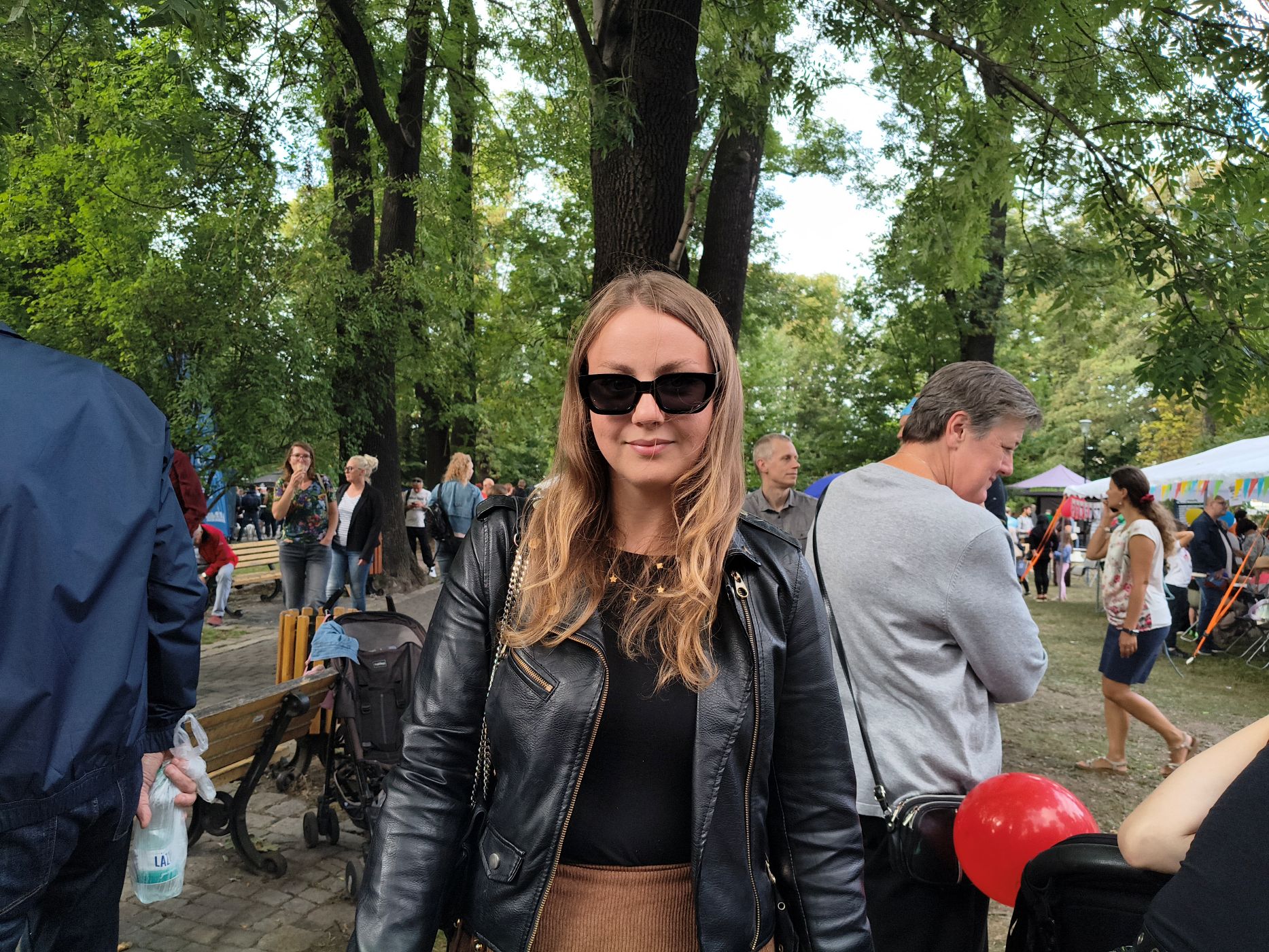 kobieta w czarnej kurtce i czarnych okularach