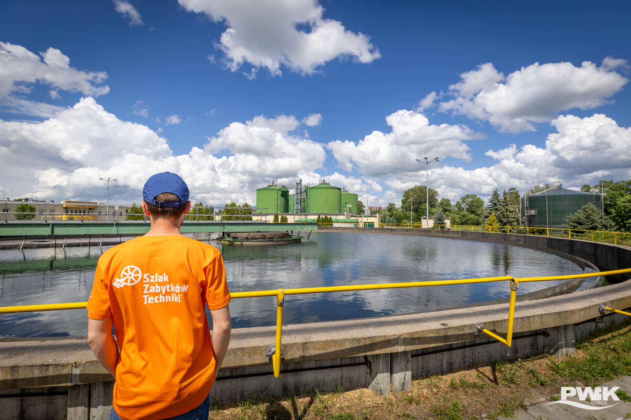 Pan w koszulce Industriady patrzący w stronę zbiornika w Centralnej Oczyszczalni Ścieków