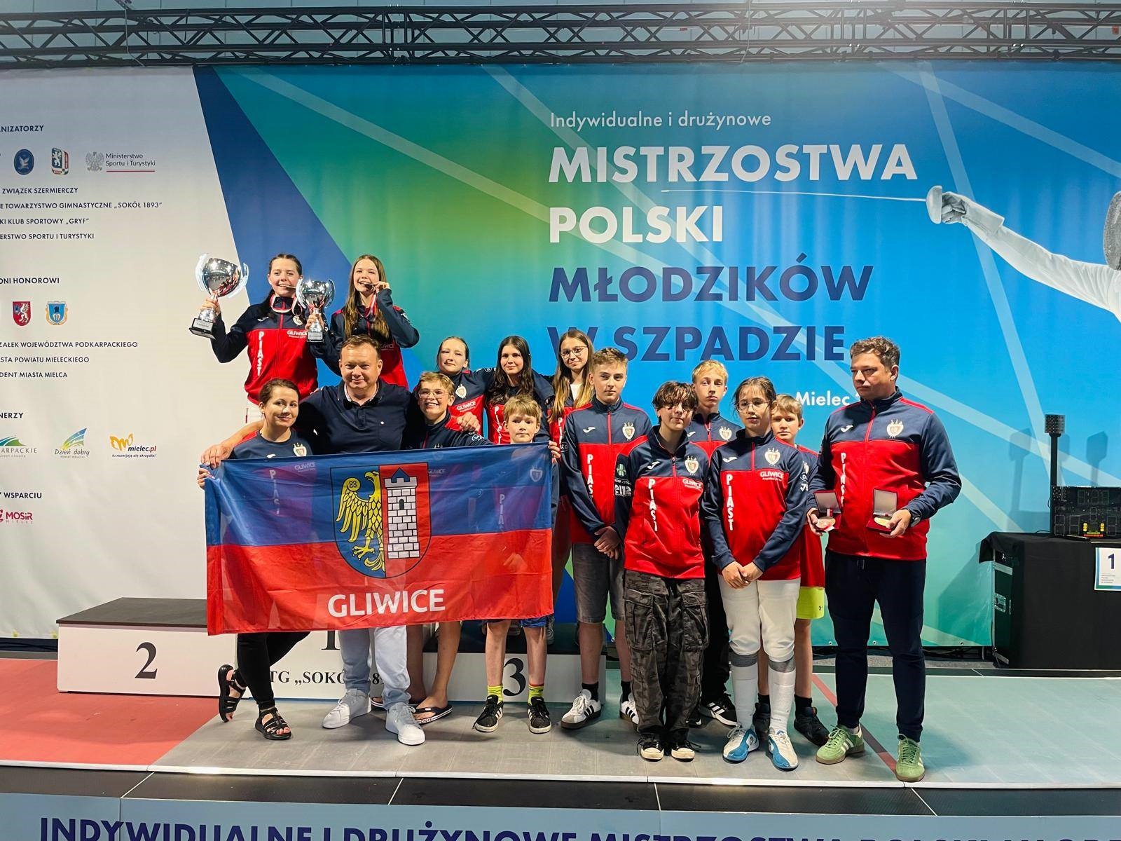 Szpadziści Piasta pozujący z flagą Gliwic
