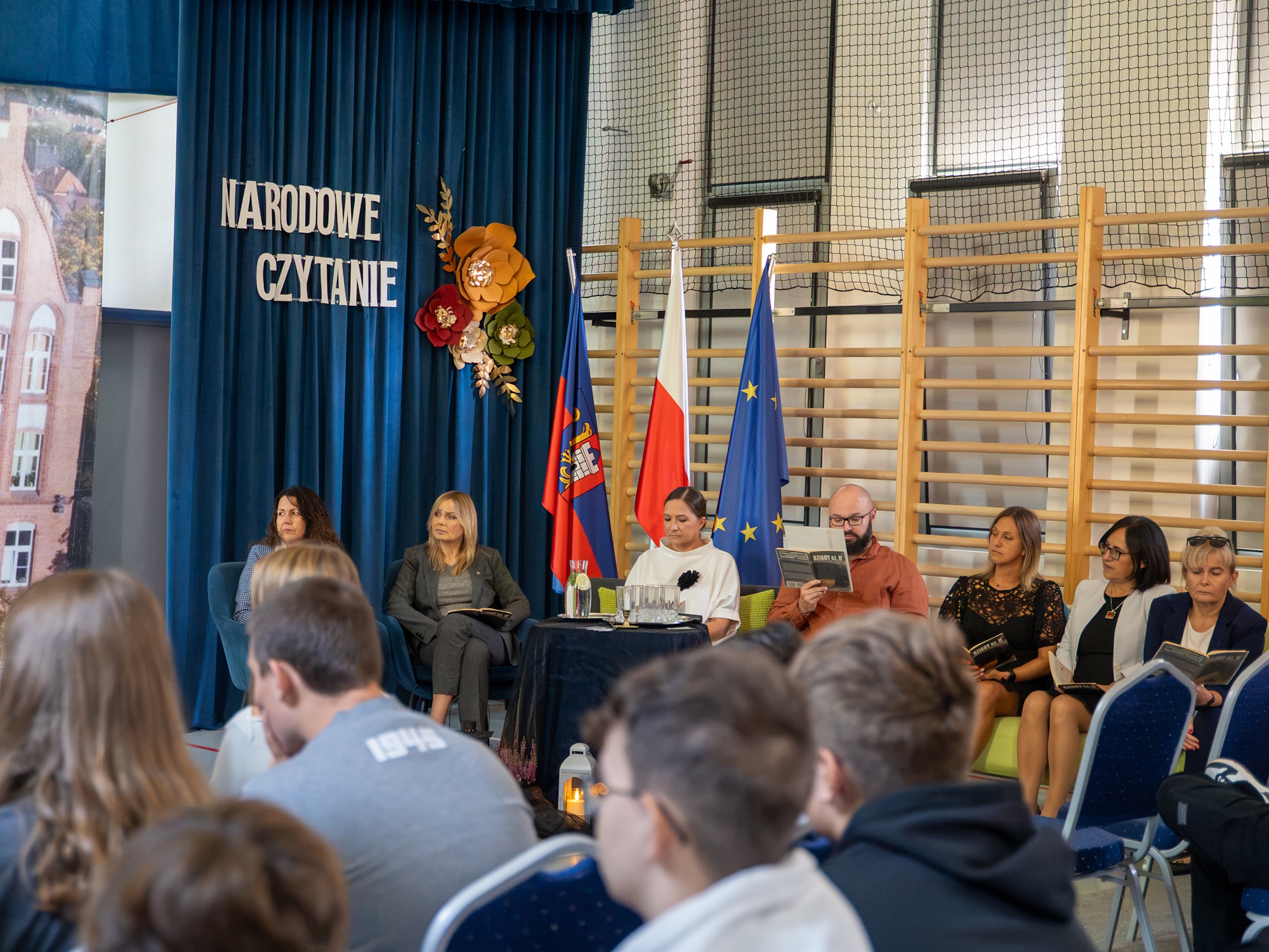 Dzieci słuchające dorosłych czytających książki
