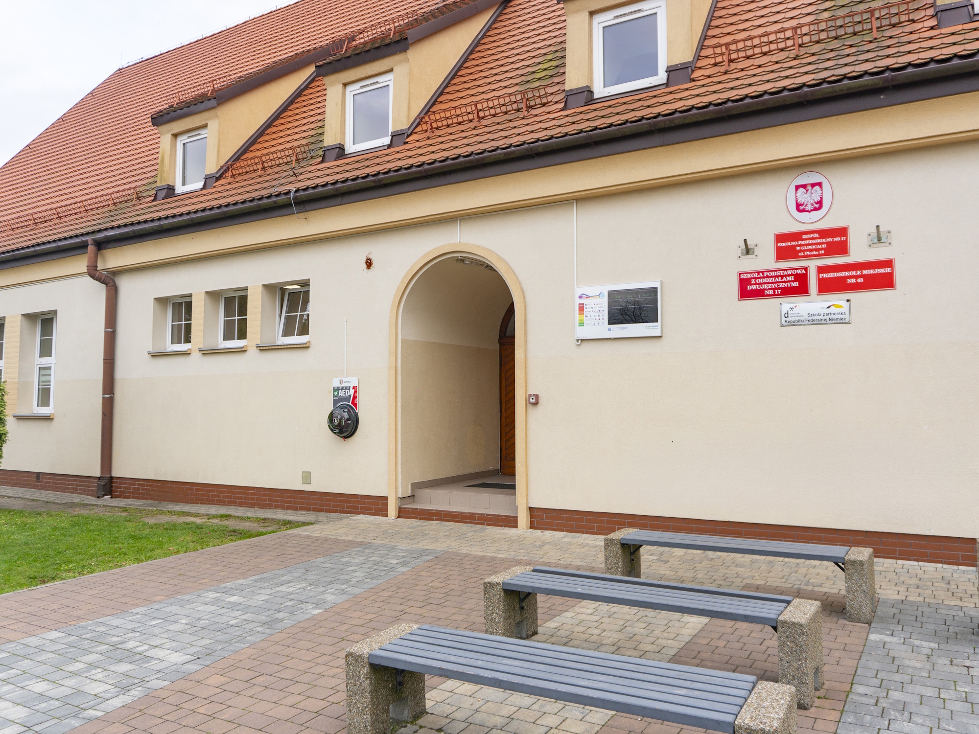 Budynek szkoły, na ścianie defibrylator