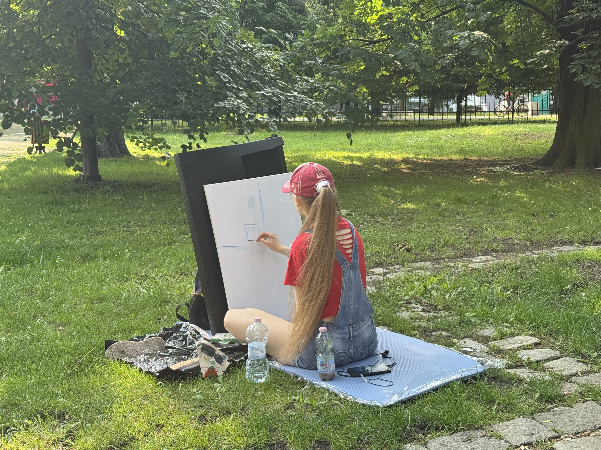 Fot. materiały UM Gliwice dziewczyna na trawie siedzi i maluje na sztaludze
