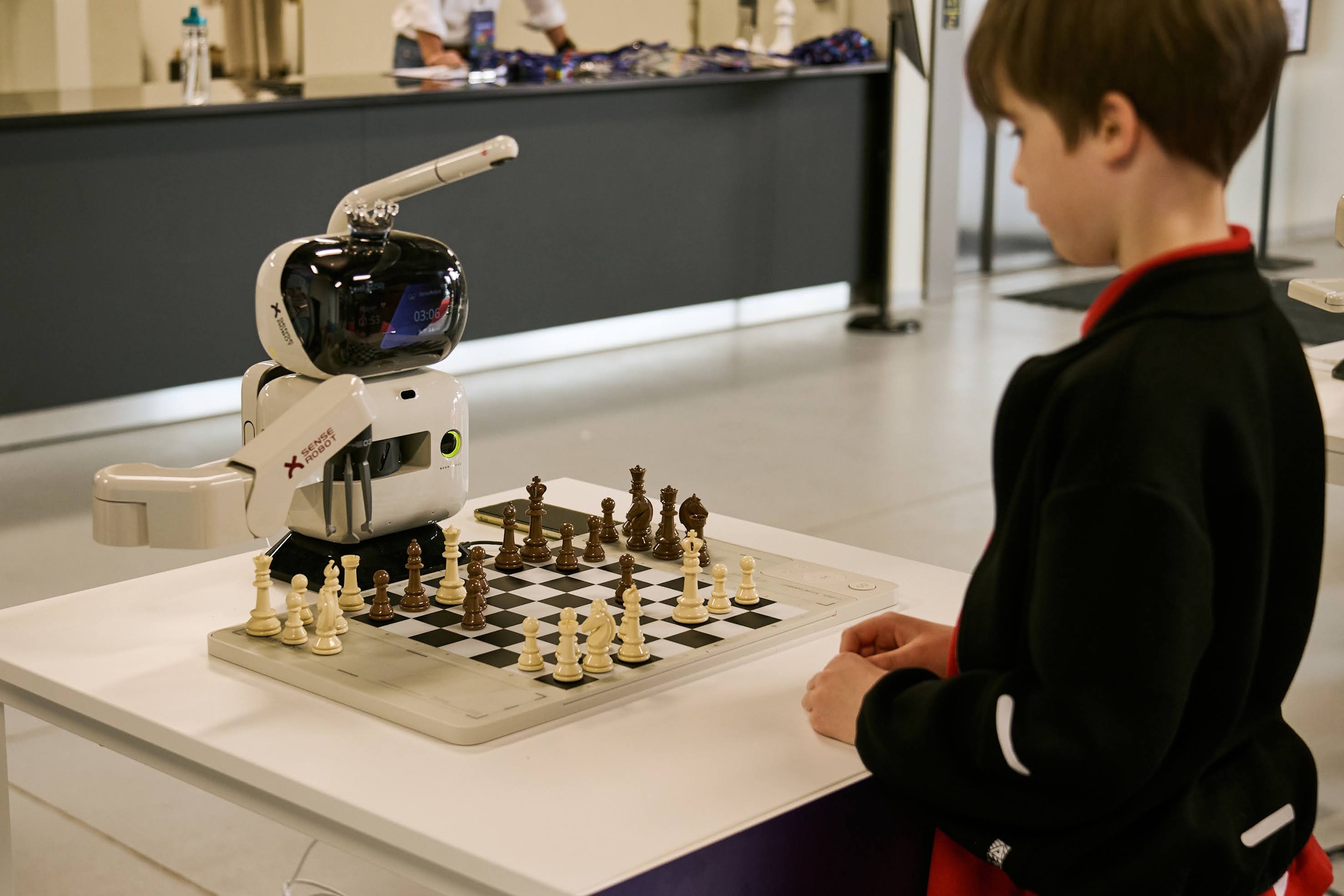 Chłopiec grający w szachy z robotem