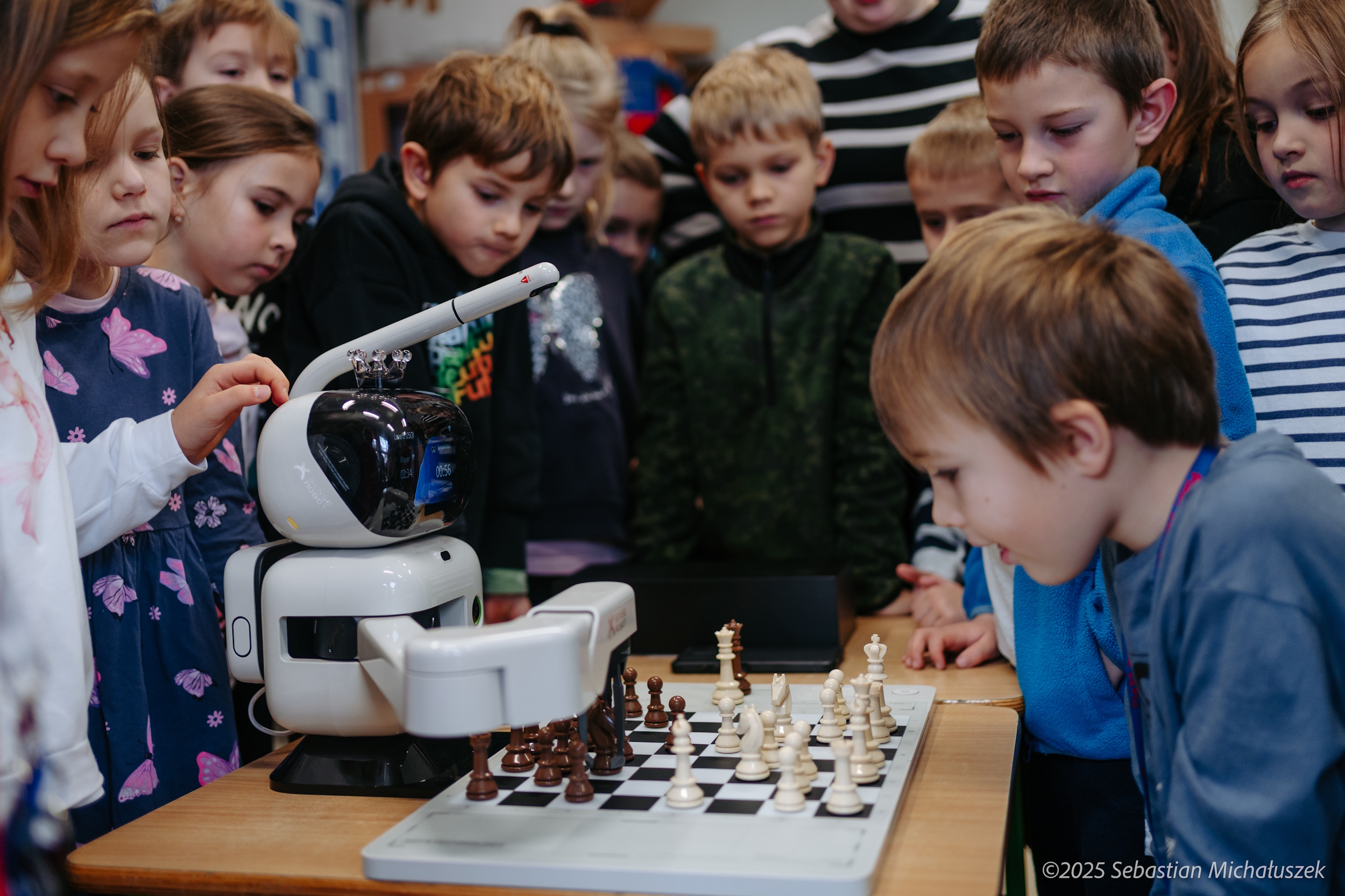 Dzieci grające w szachy z robotem