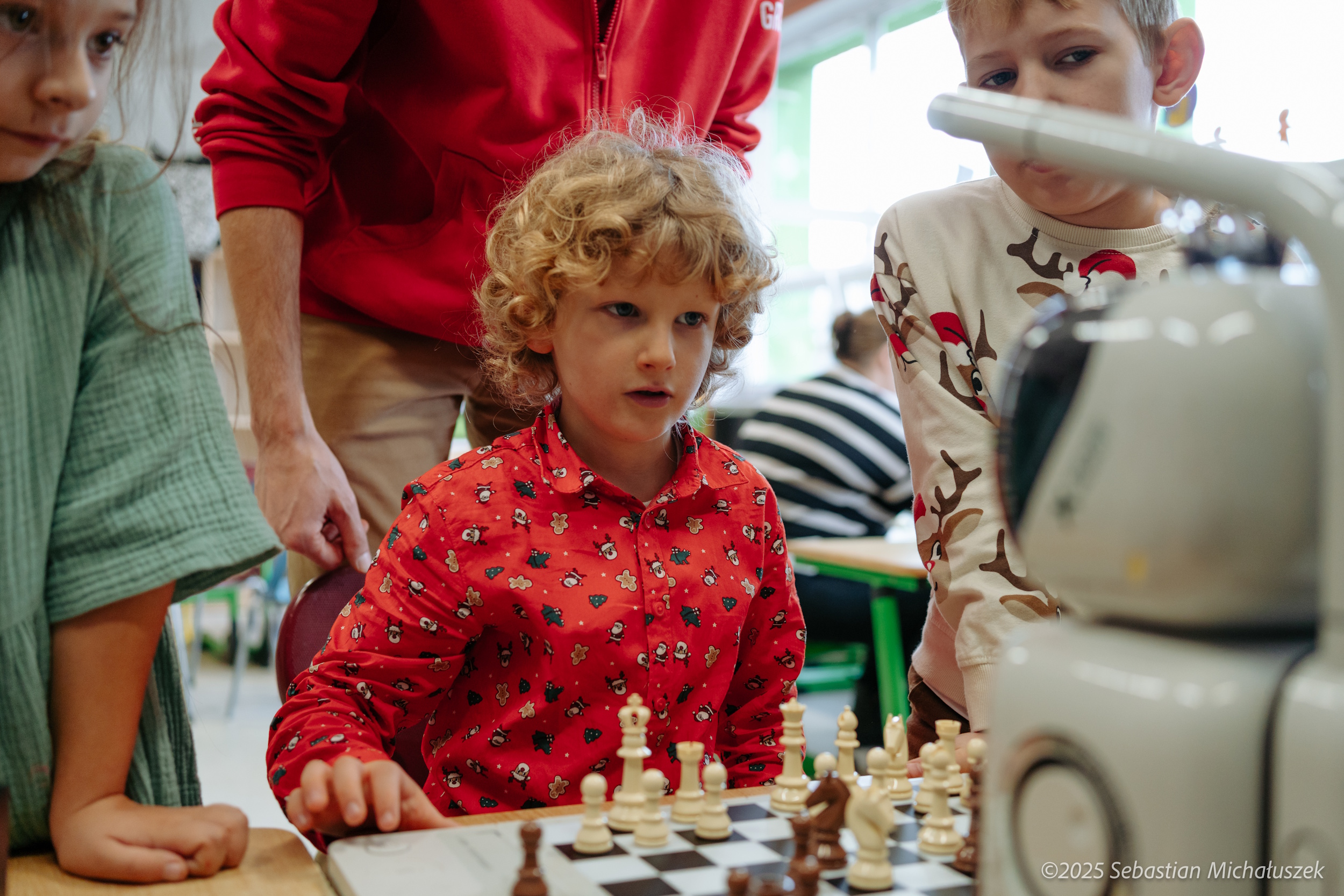 Dzieci grające w szachy z robotem