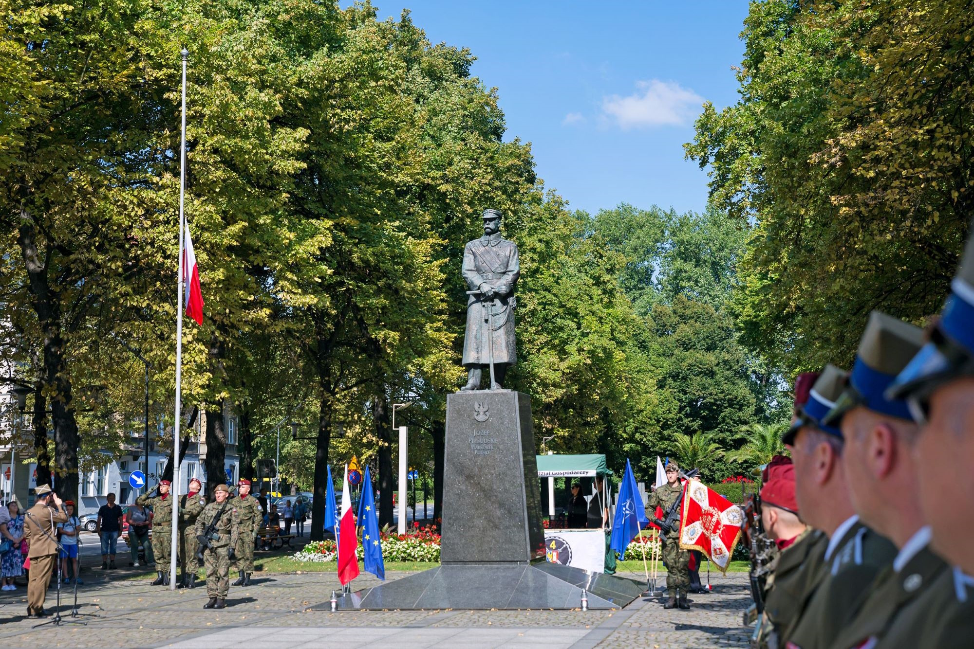 pomnik, drzewa, ludzie