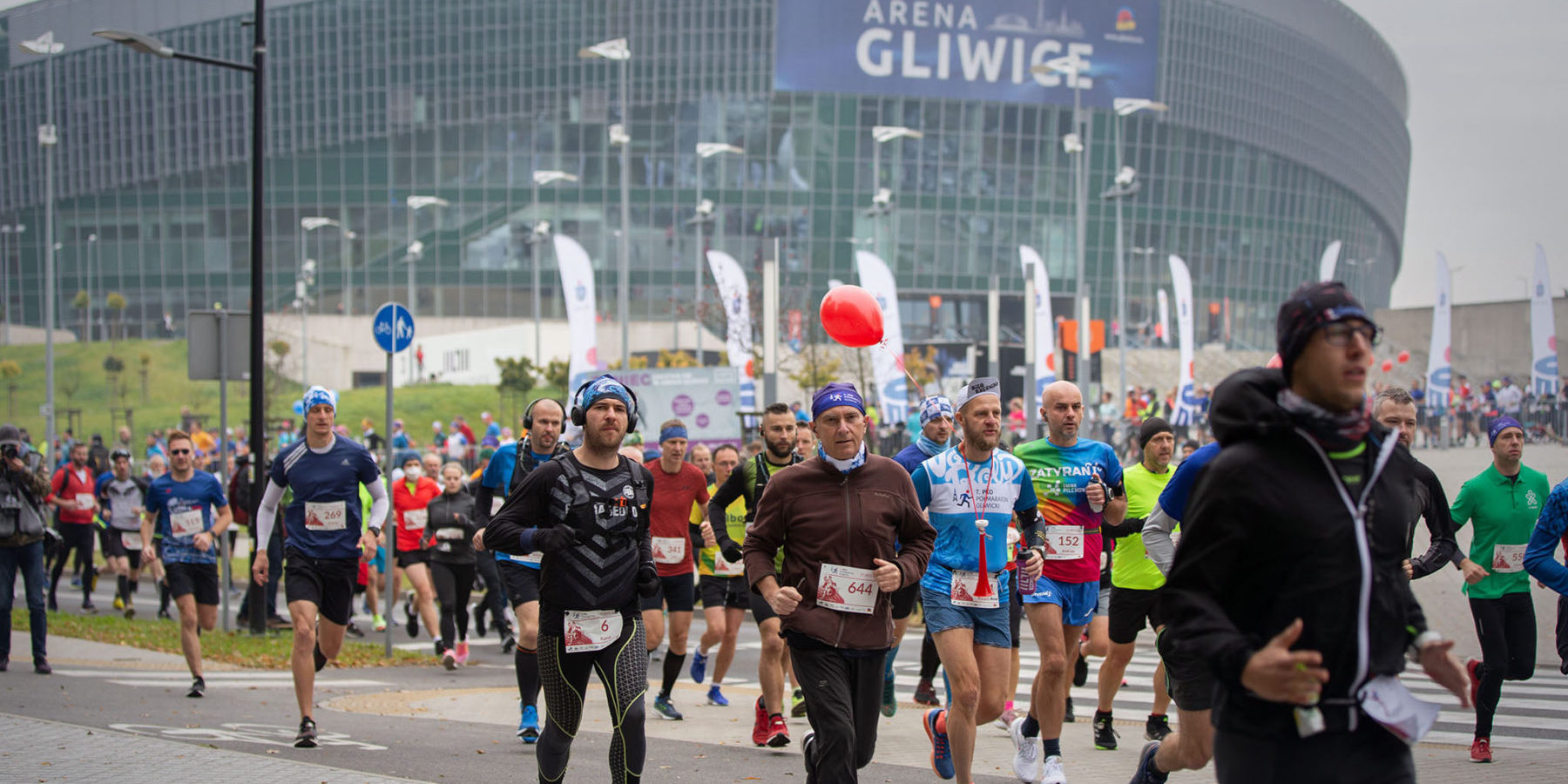 na zdjęciu widoczni uczestnicy półmaratonu, w tle arena Gliwice