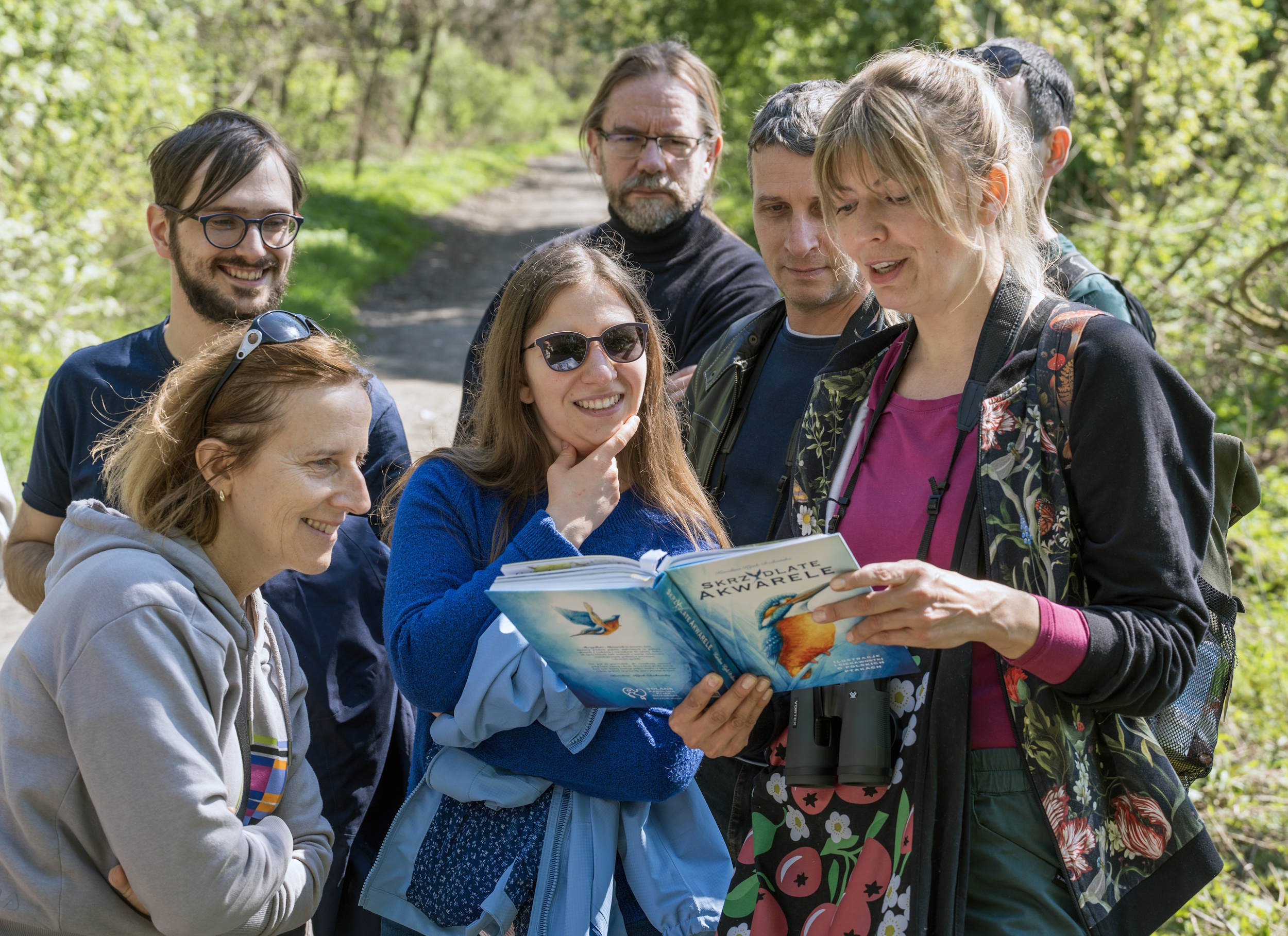 Uczestnicy spaceru oglądający książkę o ptakach 