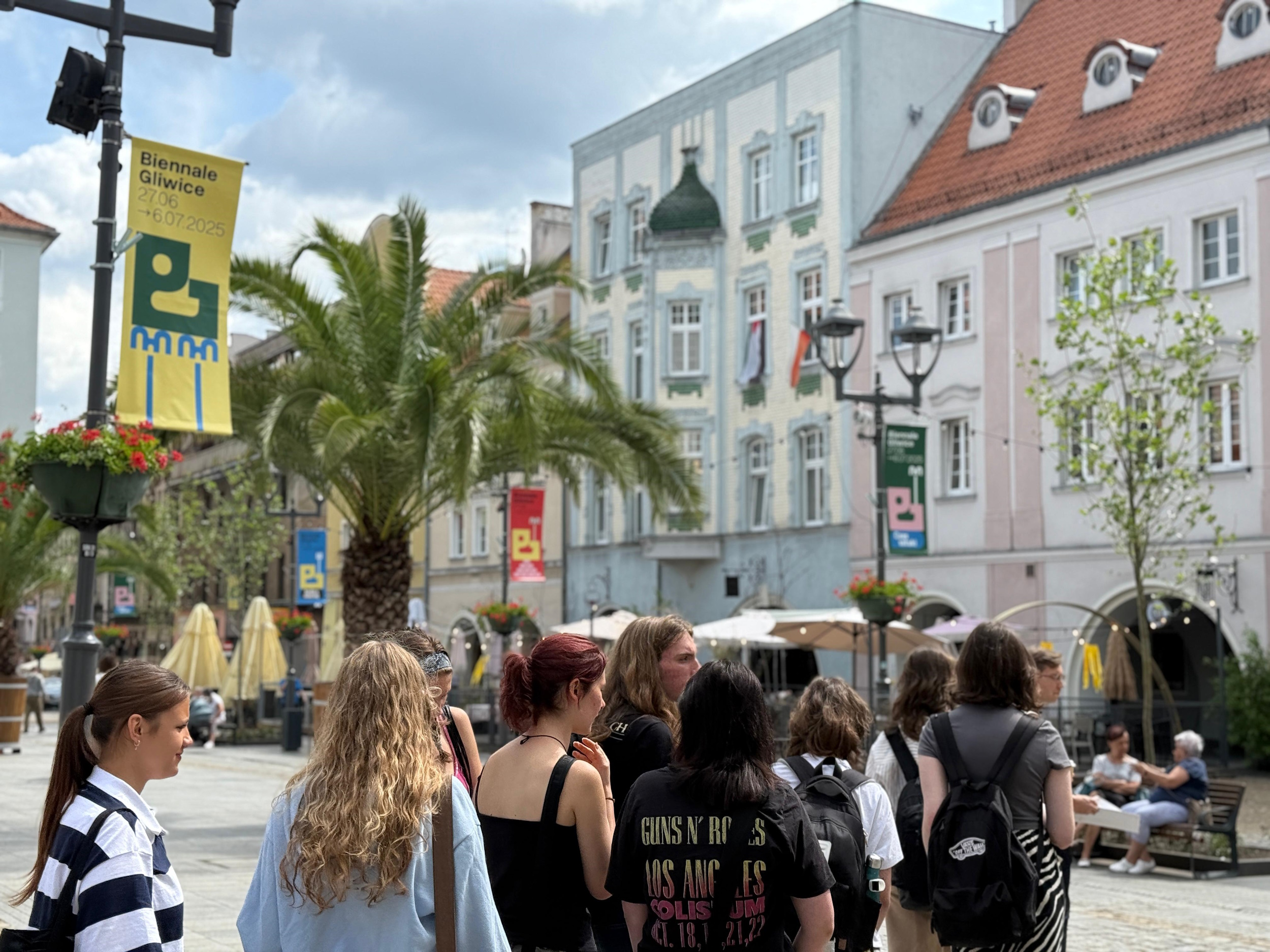 Młodzież na rynku, pod plakatem Biennale Gliwice