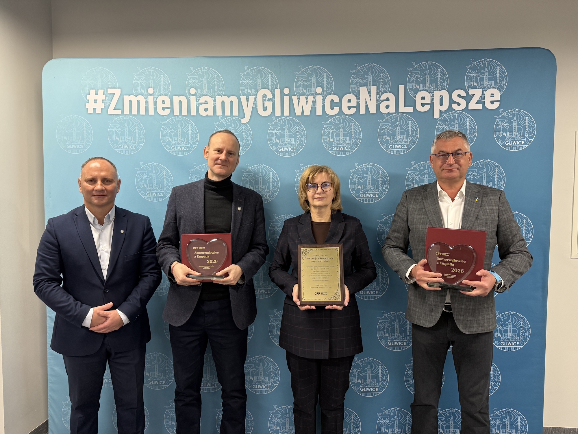 czworo ludzi z nagrodami na ściance