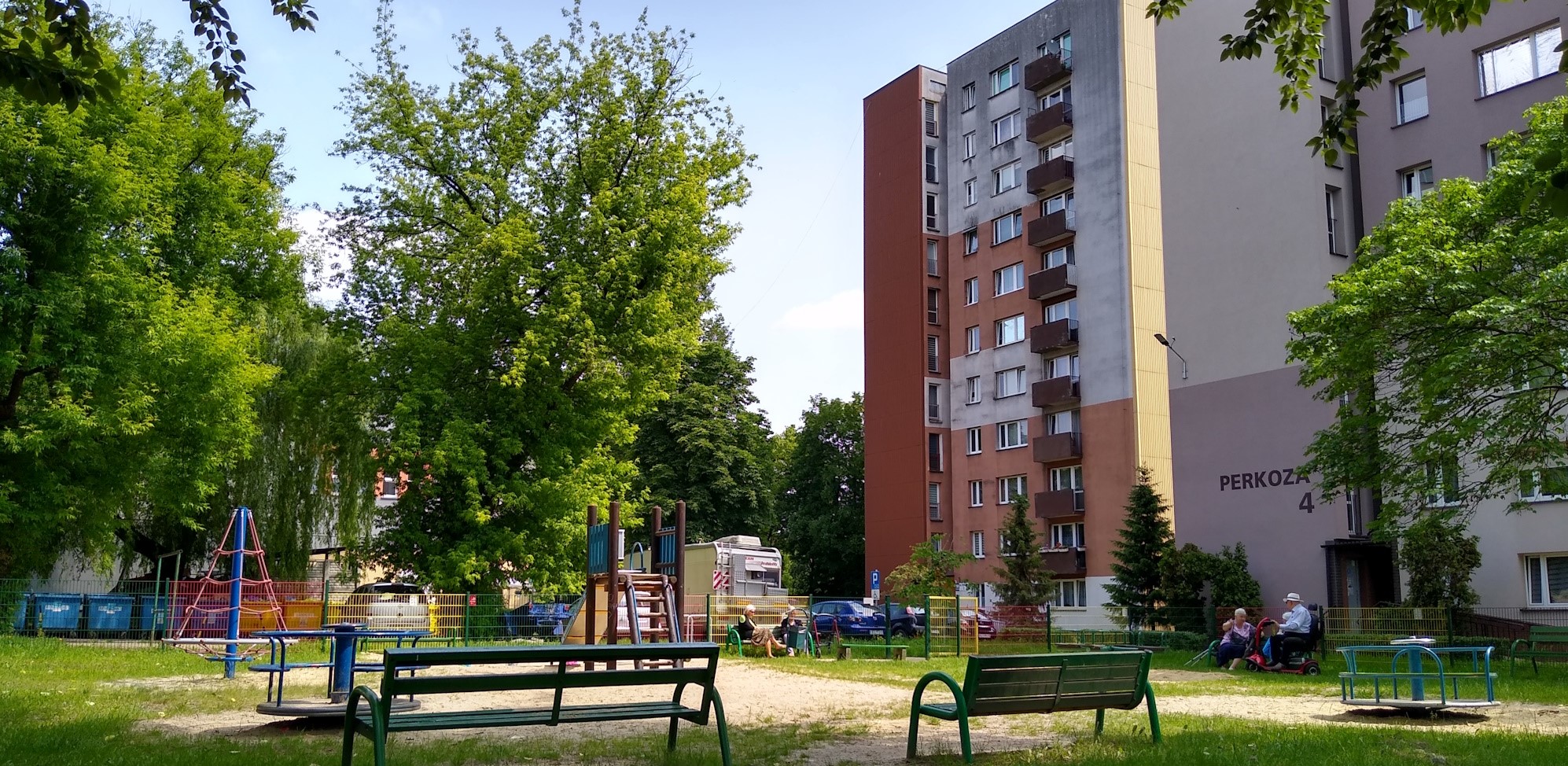 plac zabaw, na ławkach siedzą starsze osoby