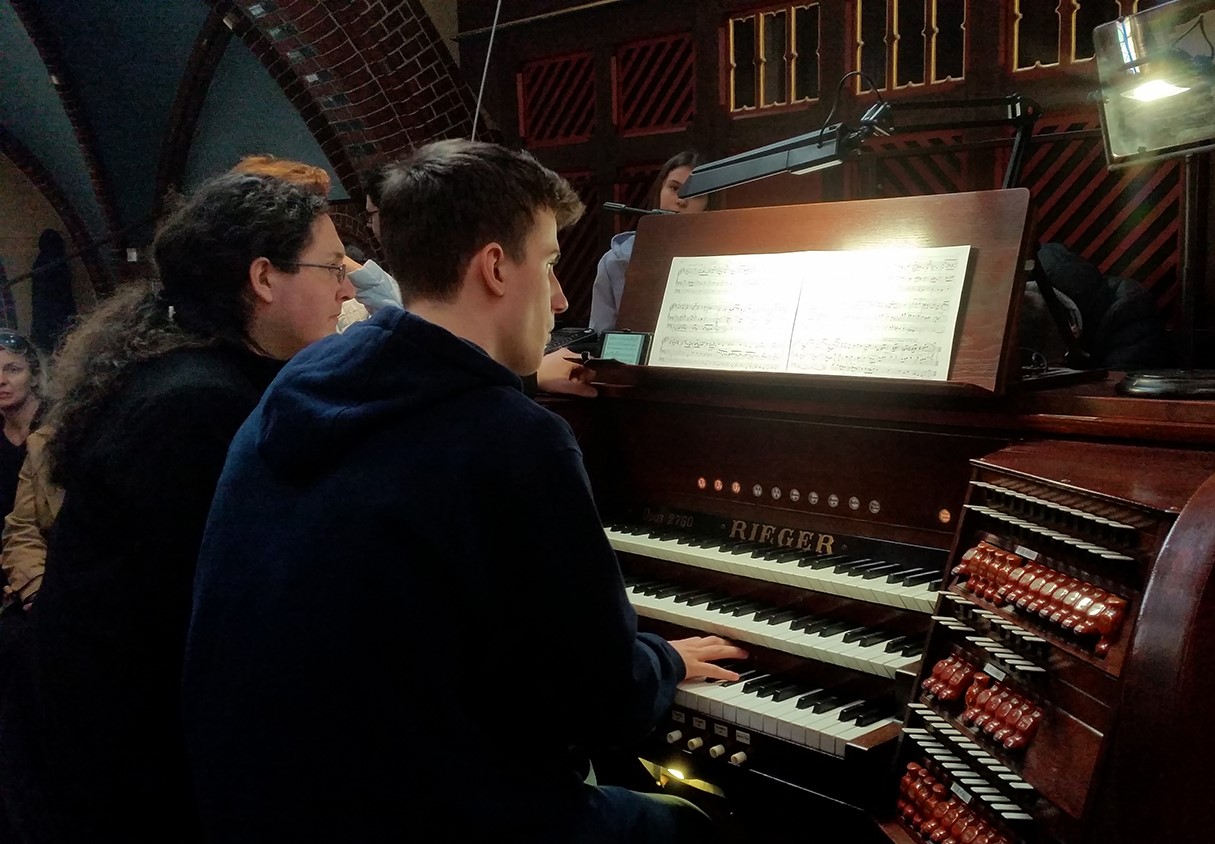 Dwóch mężczyzn siedzi przy organach