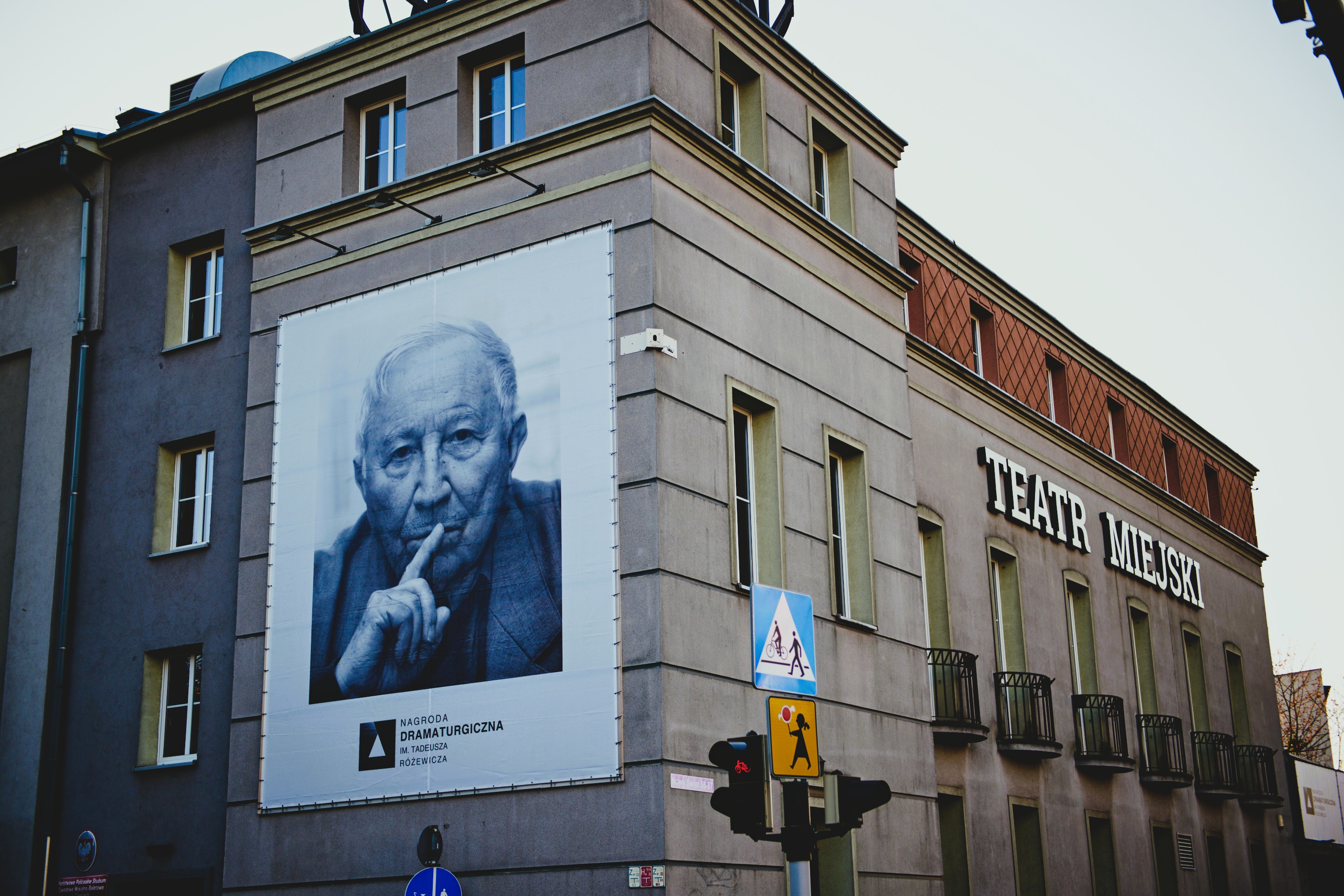 Budynek Teatru Miejskiego w Gliwicach z ogromnym plakatem, na którym widnieje Różewicz