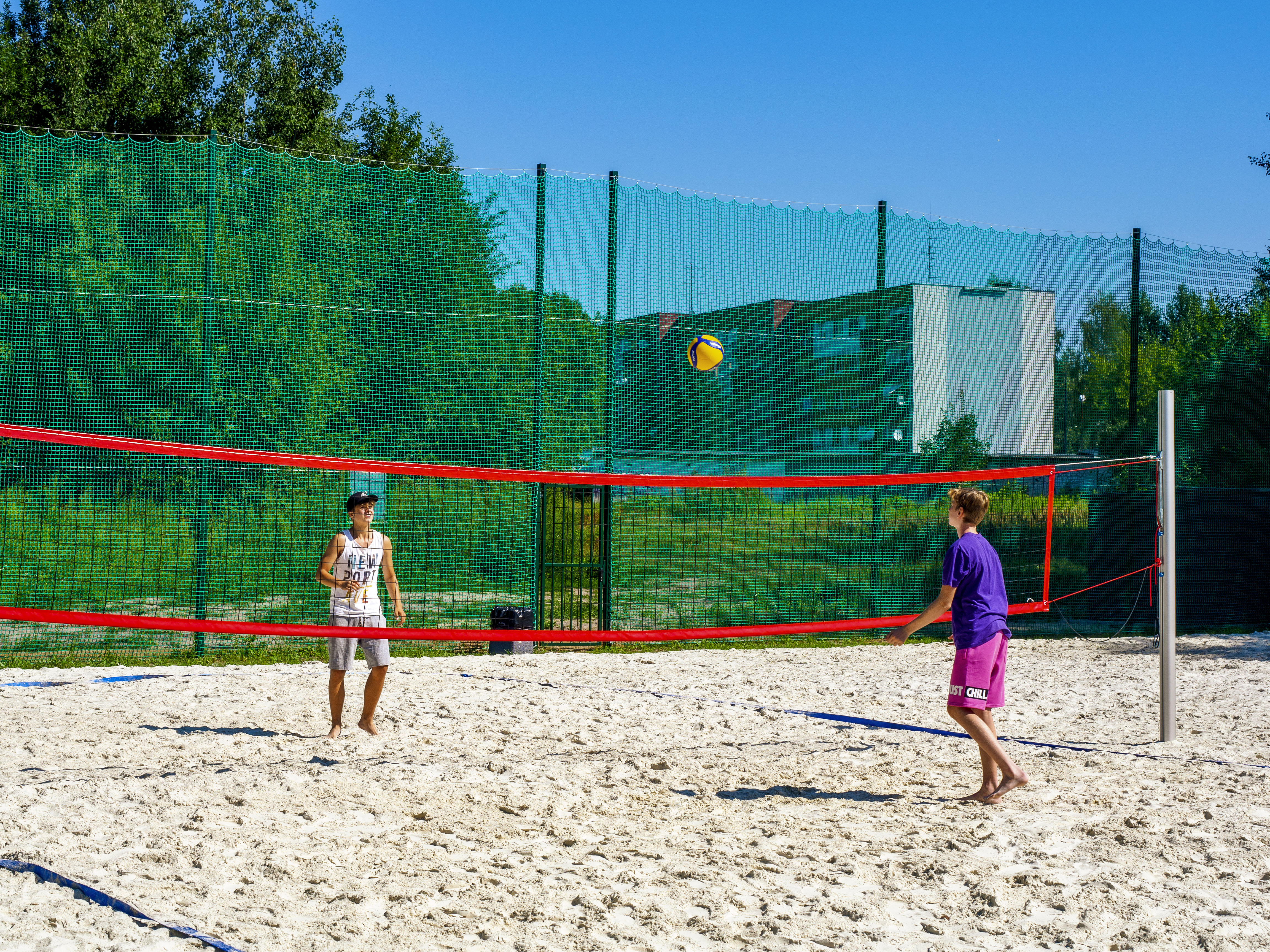 Chłopcy grający w siatkówkę plażową na nowym boisku