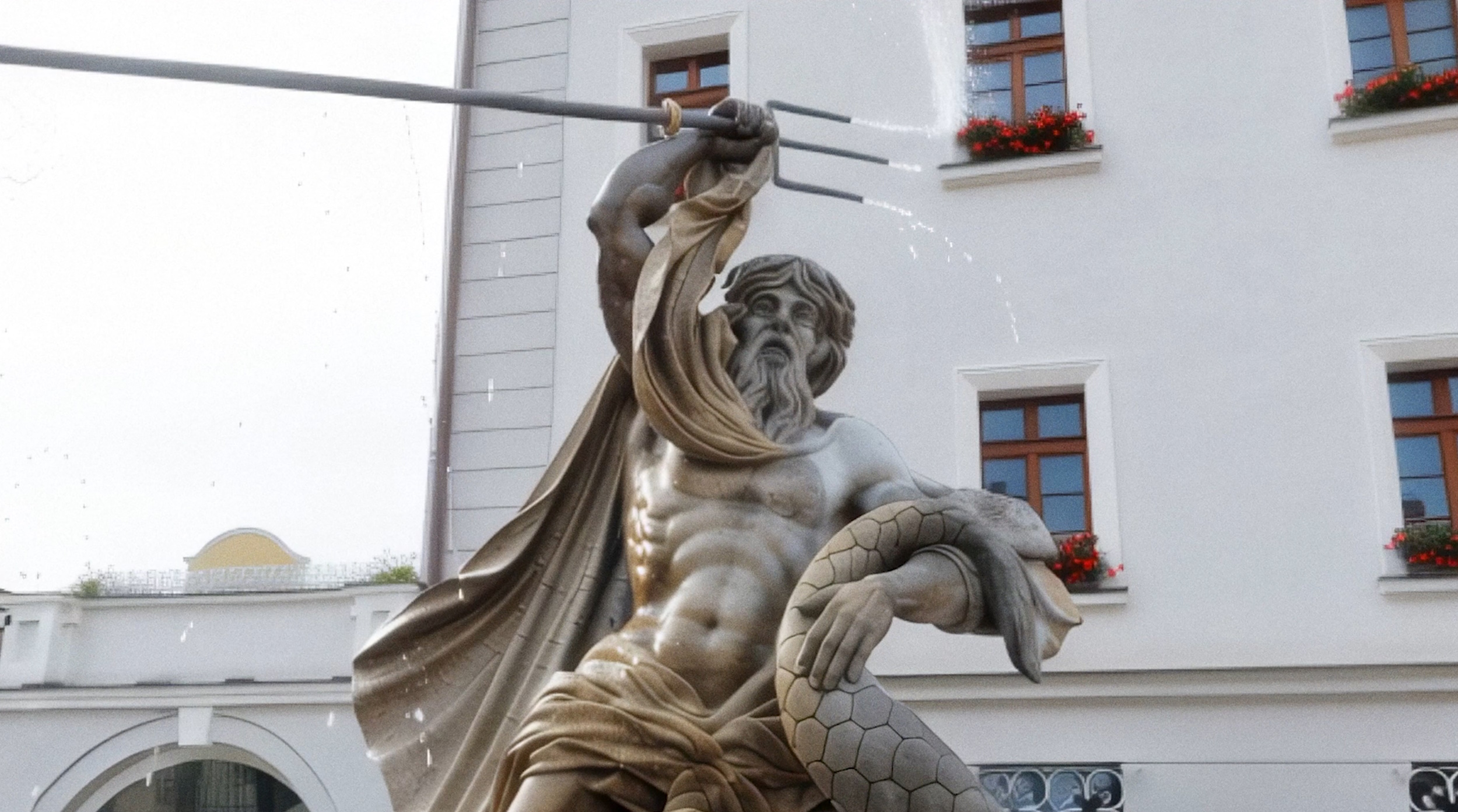 Neptun na pomniku na rynku wywijający harpunem