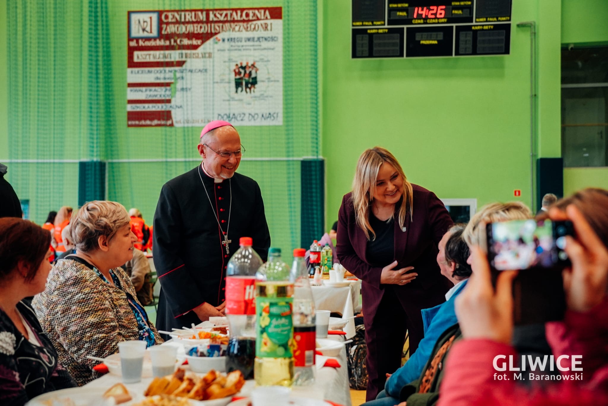 Prezydent Gliwic i Biskup dzielący się opłatkiem z potrzebującymi