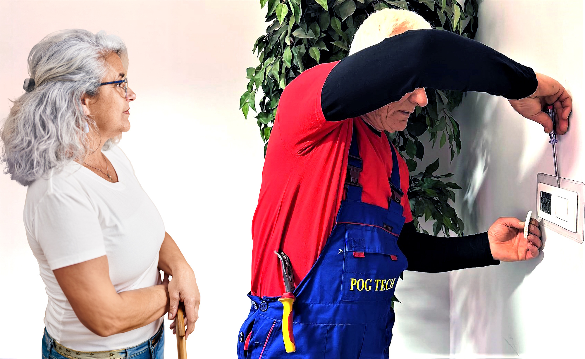 pan naprawia kontakt, obok stoi kobieta w białej bluzce, ma siwe włosy